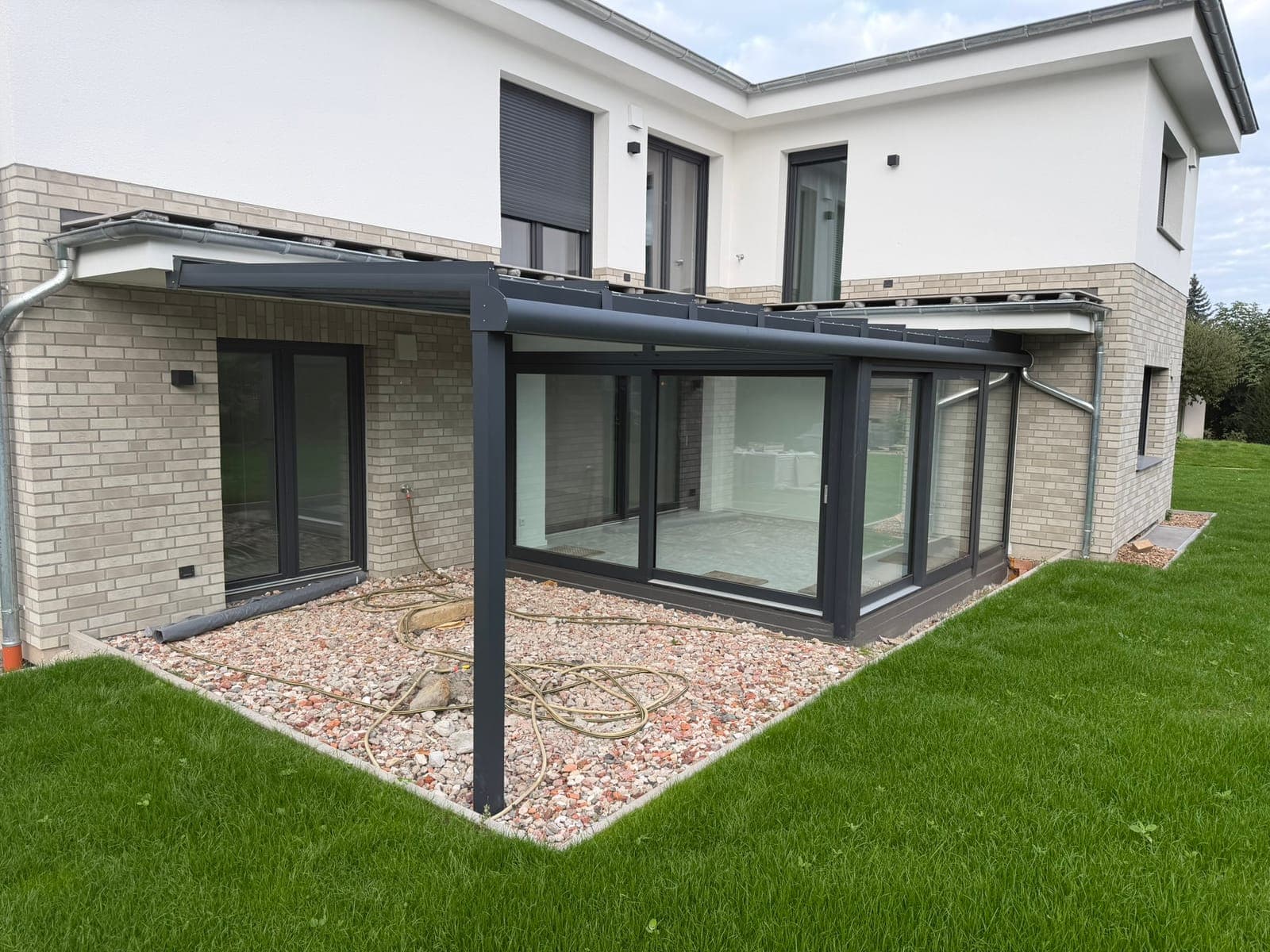 Anthrazitfarbener Wintergarten mit integrierter Terrassenüberdachung aus Glas in Bad Oeynhausen